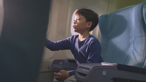 boy playing with toy airplane on airplane