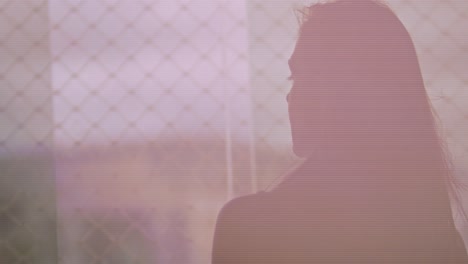 silhouette of brunette woman admiring view outside apartment, slow motion