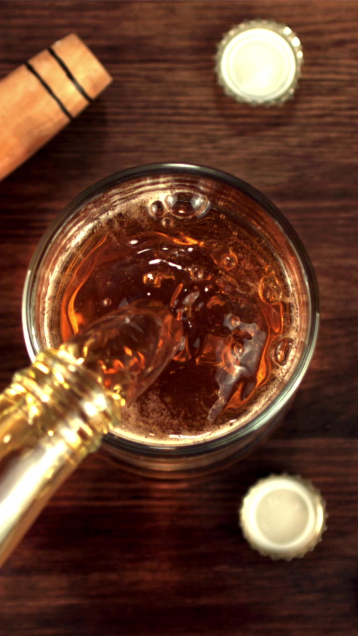Birra dorata che si versa in un bicchiere al rallentatore.
