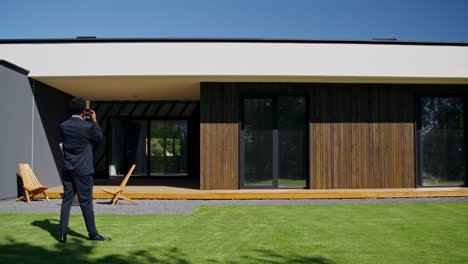 real estate agent photographing modern home exterior