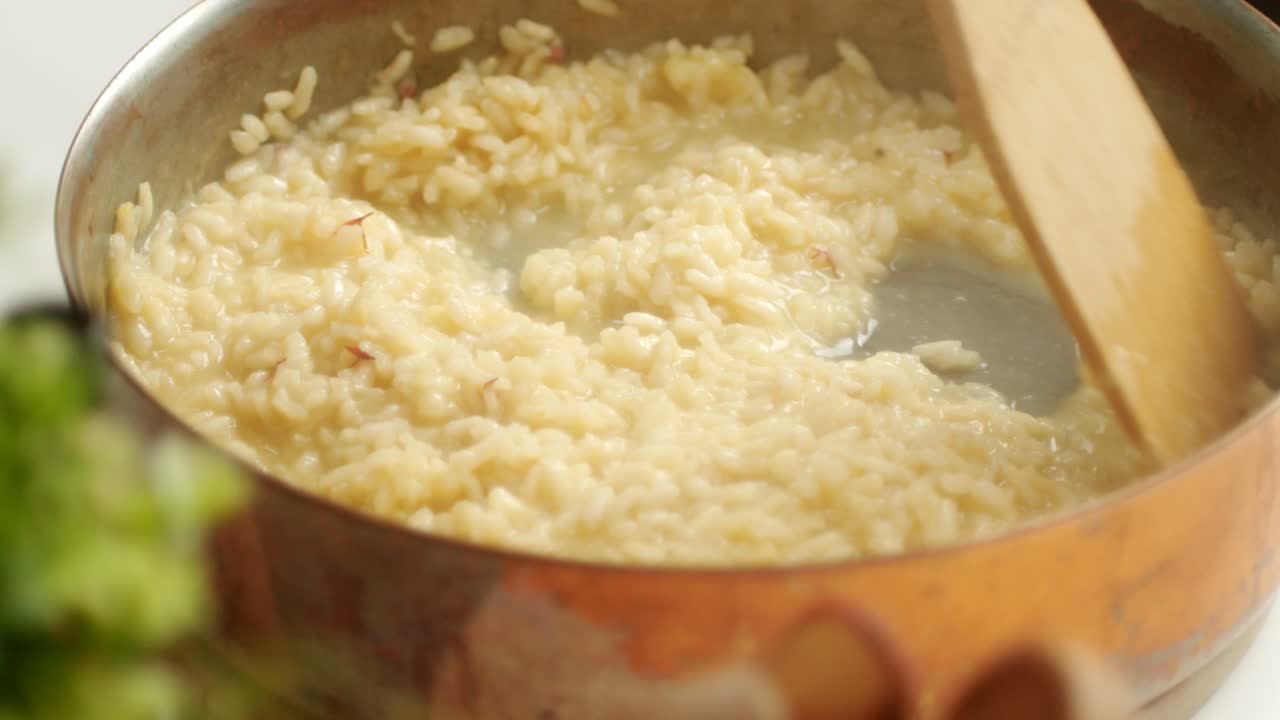 Ugjenkjennelig kokk tilbereder risotto i panne