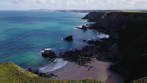 cliffs and turquoise ocean of godrevy beach in cornwall, england - drone shot