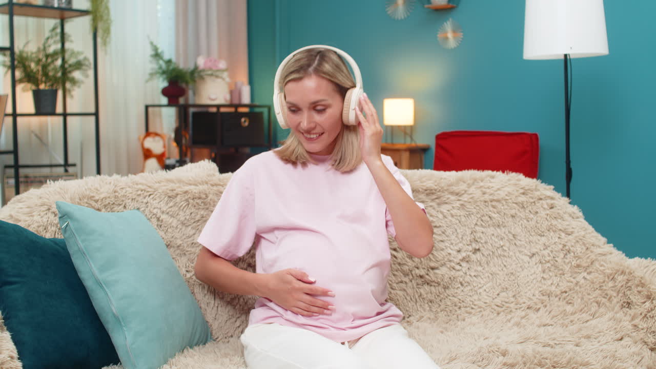 Pregnant woman dancing with headphones relaxing gentle moves enjoying music rhythm smile joy smiling
