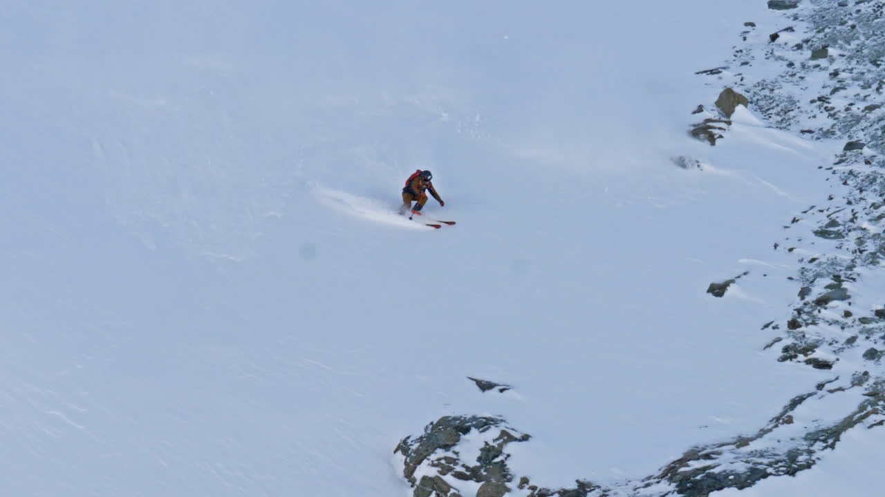 High-energy footage of a freeride skier charging down a steep alpine face and jumping multiple cliffs in Saas-Fee. Big-mountain skiing, speed, airtime, and control in the Swiss Alps