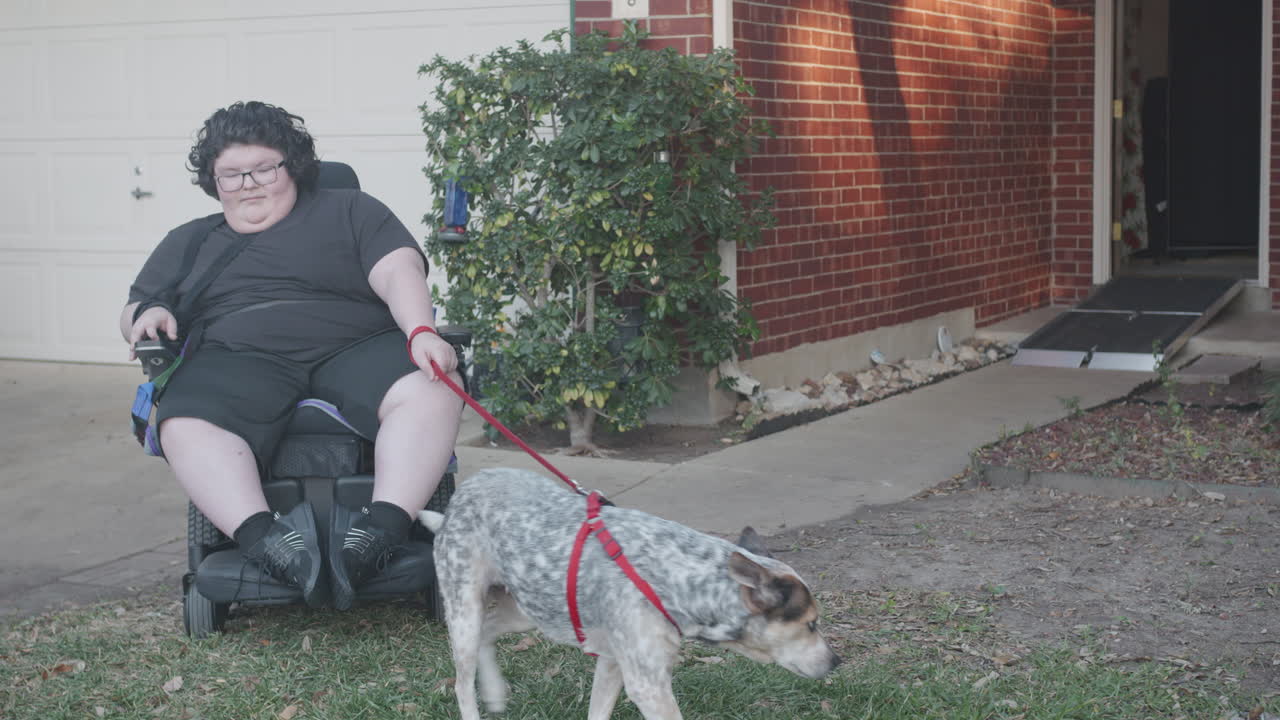 Muscular Dystrophy adolecsent in wheelchair with dog and mom leaving home