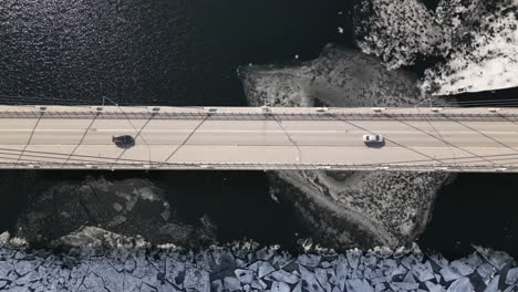 cars passing over bridge, icy landscape