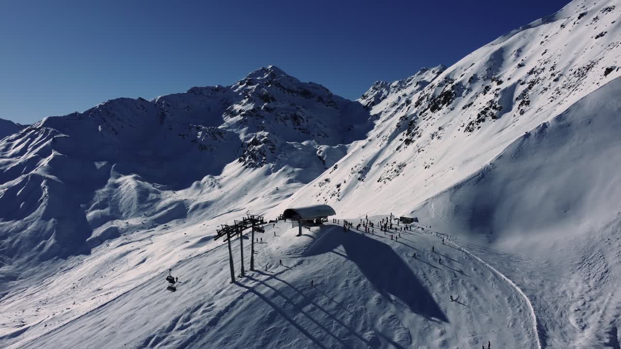 estación de elevación de sillas en lo alto de los alpes durante la temporada de deportes de invierno, aérea