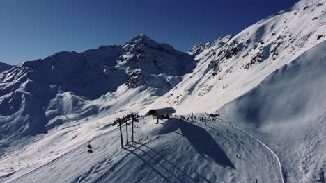 chair lift station high in alps during winter sport season, aerial