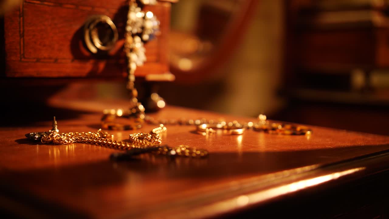 Close-up of a woman's hand selecting a gold earring from a vintage jewelry collection
