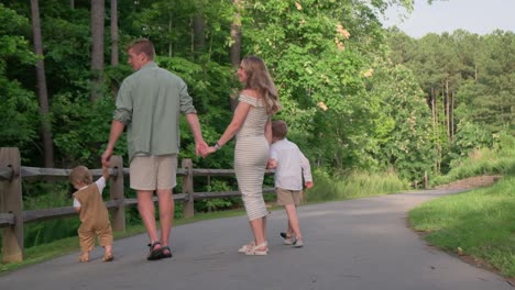 a family strolls together in nature sharing smiles and joy a heartwarming family outing occurs as a group strolls hand in hand through nature sharing joy and smiles in a lush park