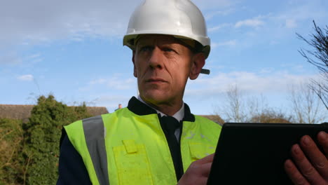 portrait of an architect construction building inspector using a tablet on a building site on a residential street