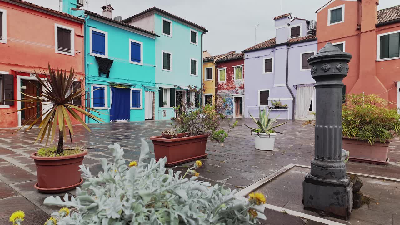 Communal water fountain with decorative plants and painted houses