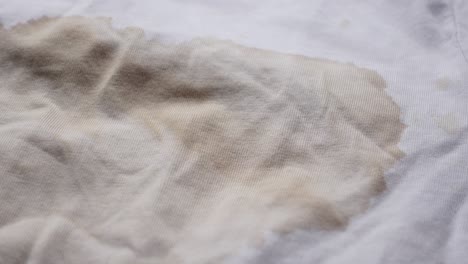 close up of a coffee stain on a white t-shirt