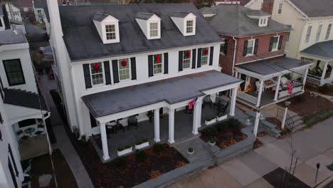 american flags adorn homes decorated with christmas wreaths