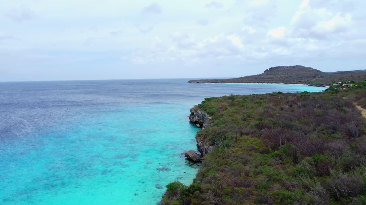Aerial Establishing shot of Tropical Island Cliff Overlooking Clear Turquoise Sea Water