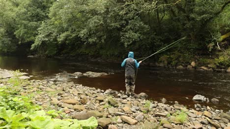 Hand-held-shot-of-a-flyfisherman-casting-into-a-quick-flowing-section-of-a-river