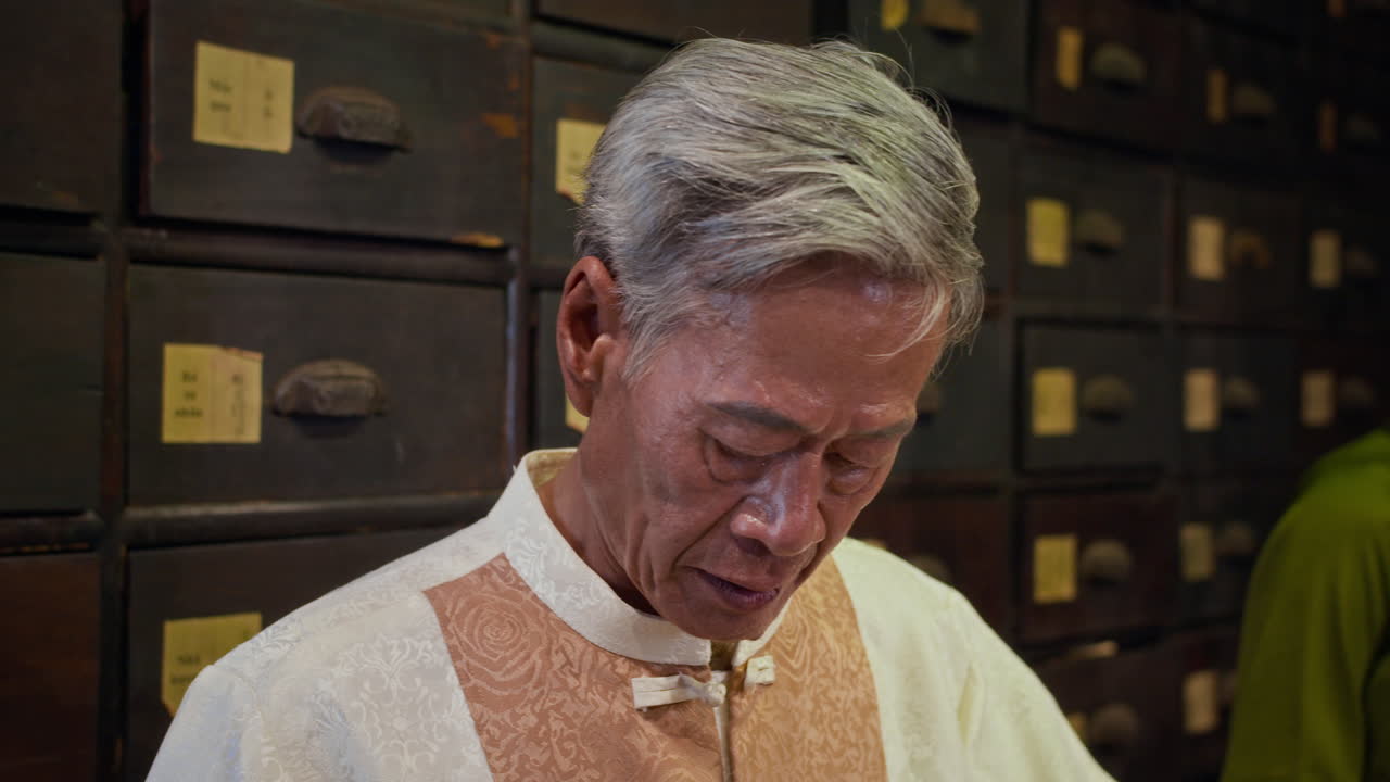 Asian Healer Using Ancient Scales to Weigh Herbs