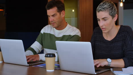 executives using laptop at desk in office 4k