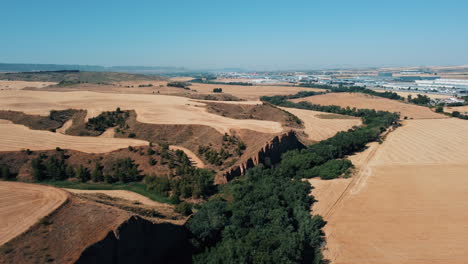 vista aérea de un paisaje rural con campos, colinas y un cañón