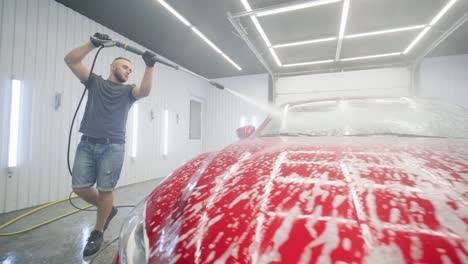 red car wash with flowing water and foam.