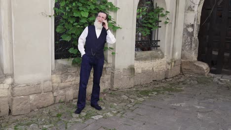 a welldressed businessman is on a phone call in a busy urban setting with buildings and greenery