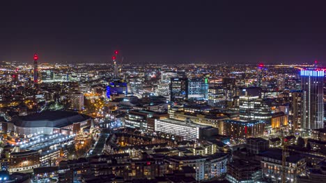 Hiperlapso-Aéreo-Nocturno-Del-Centro-De-La-Ciudad-De-Birmingham-Con-Aviones-En-La-Distancia