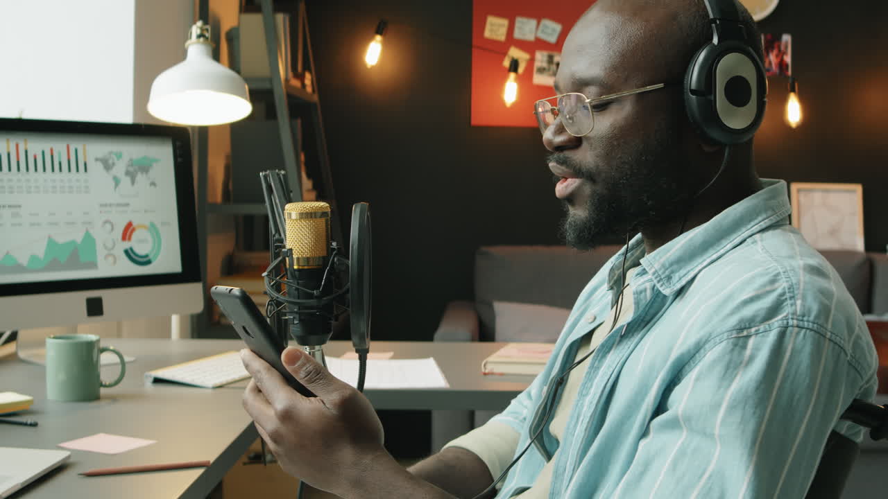 Black Man in Wheelchair Using Phone while Recording Podcast
