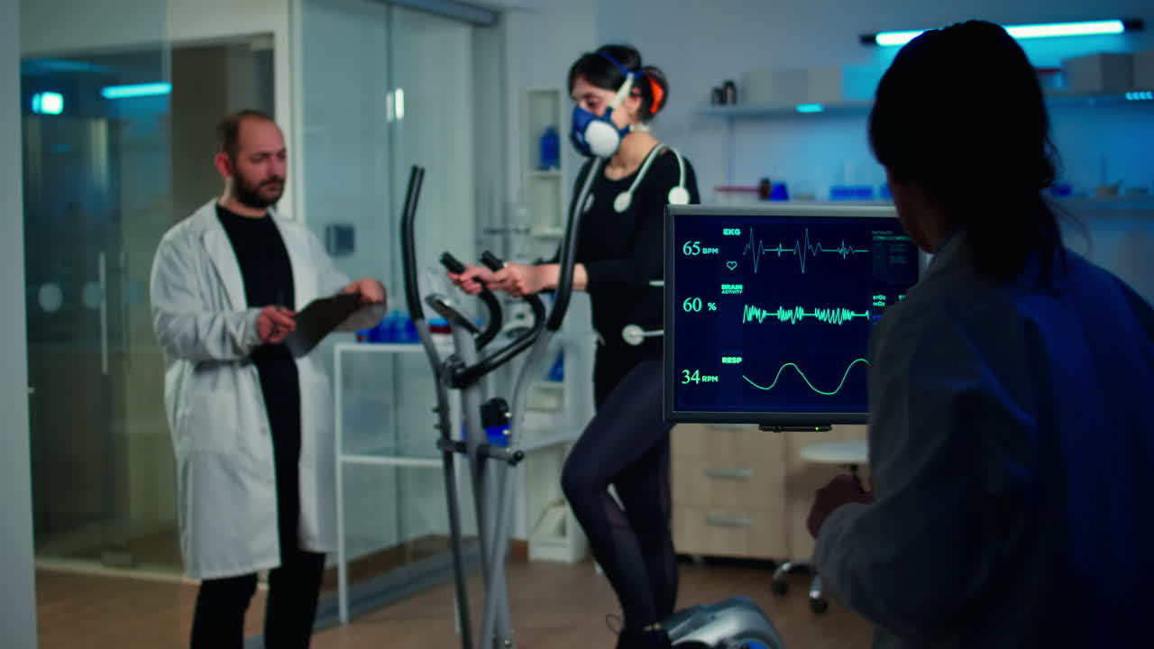 과학자가 ekg 결과를 분석하고 모니터를 보고 운동선수의 심박수를 조사하고 있습니다.