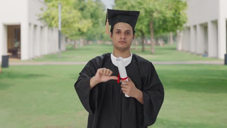 estudiante universitario indio decepcionado mostrando los pulgares hacia abajo