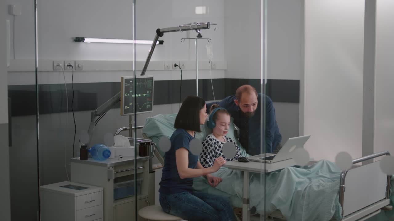 Family sitting with sick daughter in hospital ward during illness examination