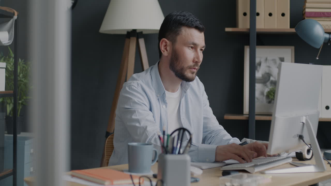 Man Working on a Computer in a Modern Office
