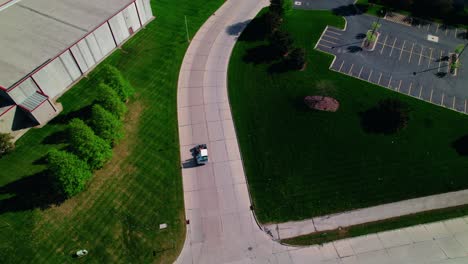 smooth drone top-down pan of a yard jockey navigating a curved driveway at a north wisconsin logistics park—ideal for industrial and transport projects.