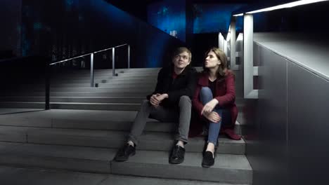 pareja sentada en las escaleras por la noche