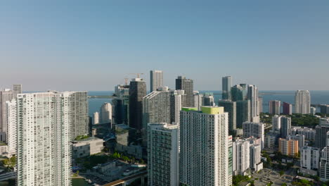 Forwards-fly-above-modern-town-development.-Group-of-high-rise-residential-buildings-along-sea-coast.-Miami,-USA