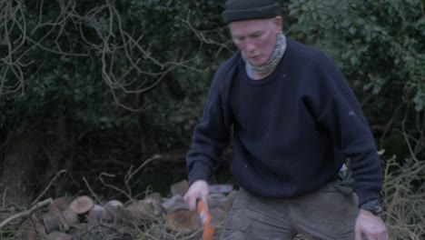 driven man chopping logs within wilderness