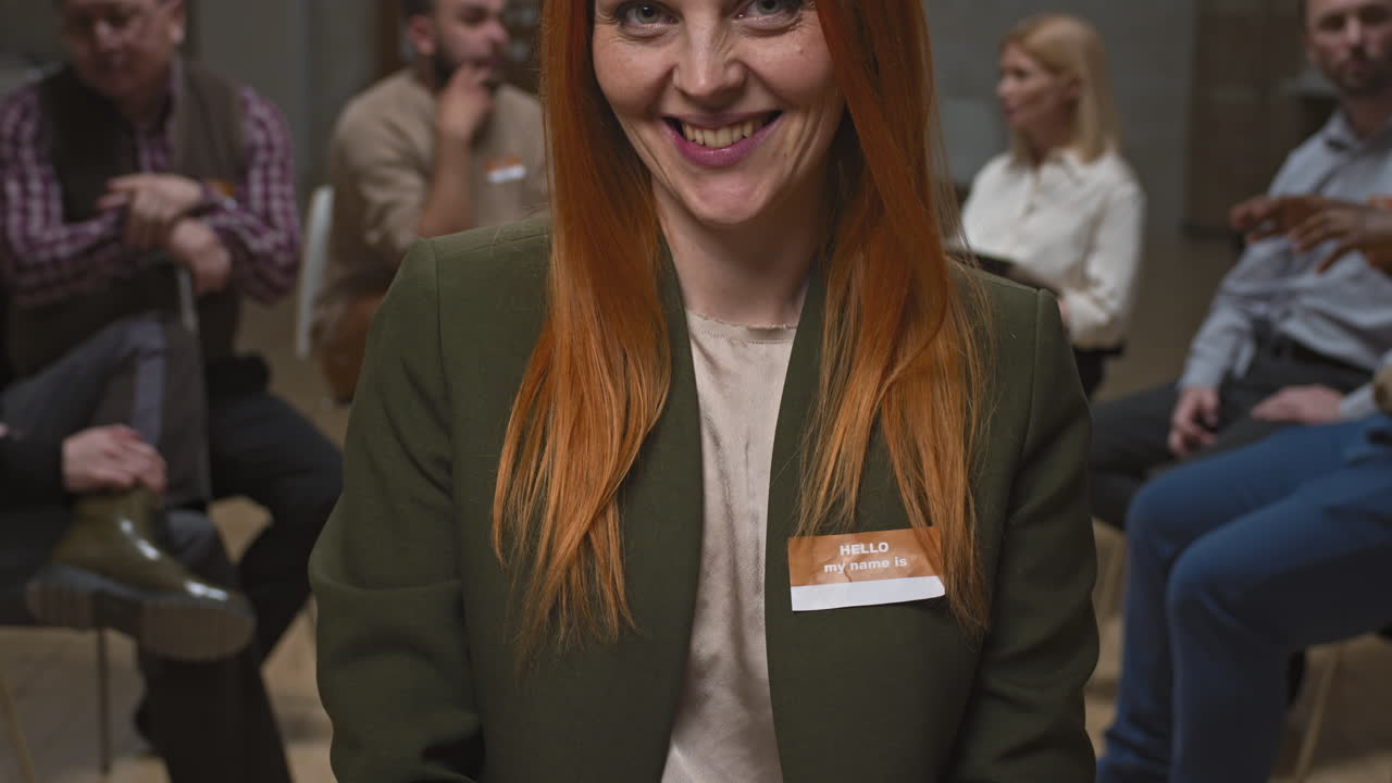 Portrait of Smiling Red-Haired Woman at Group Therapy Session