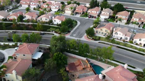 aerial shot of a giant wooden skateboard half pipe built in a residential backyard with skaters