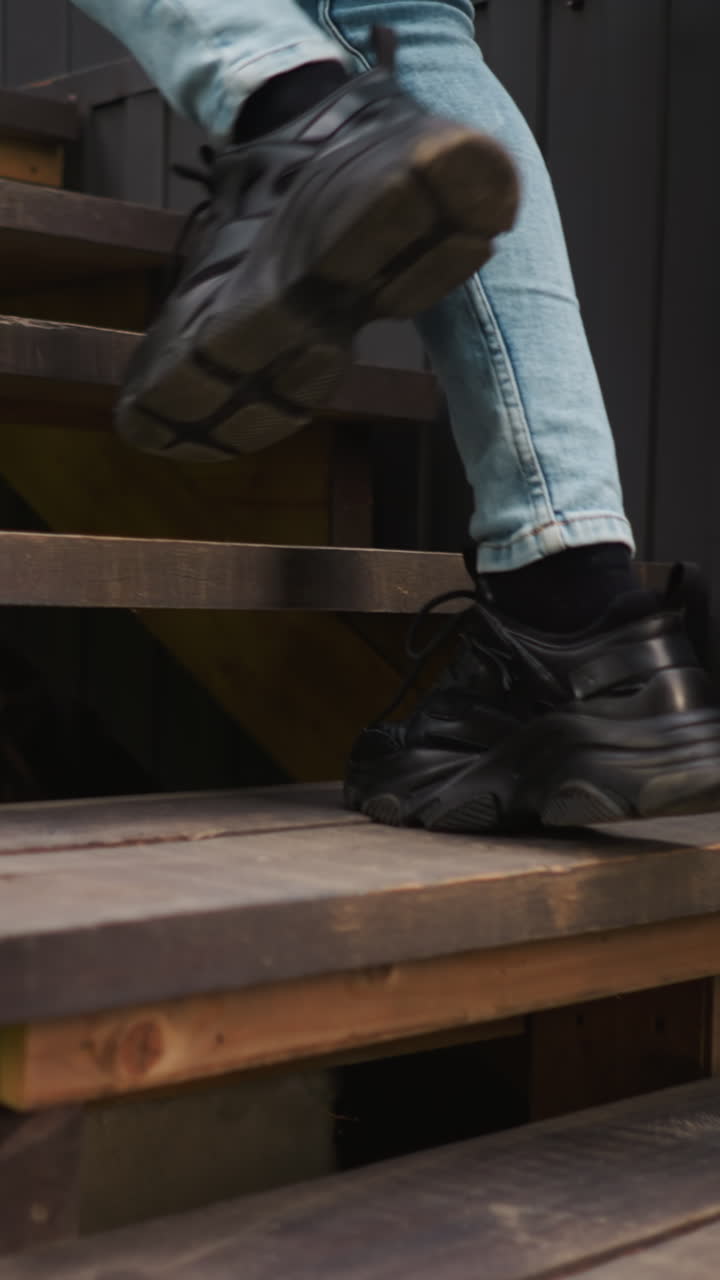 Sporty lady comes home going up stairs. Young woman prefers morning walks in fresh air in forest on glamping vacation. Woman nearly reaches cottage