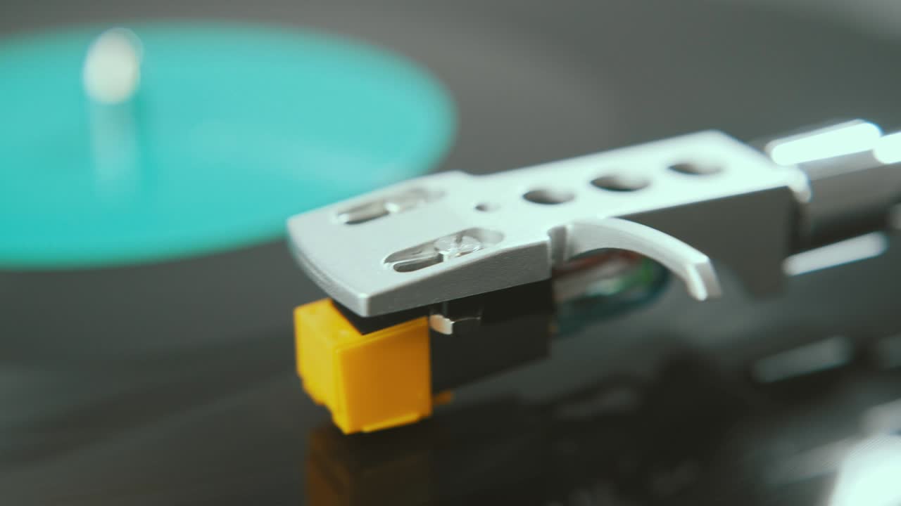 Fragment of a rotating black vinyl record player. Slide the rotating plate and stylus with a needle turntable close-up