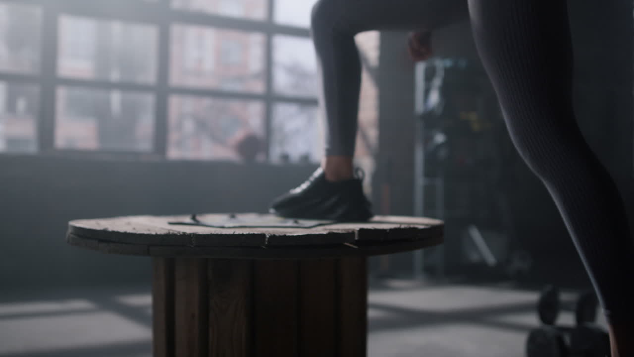 Piedi dell'atleta che saltano su una cassa di legno. Donna che allena le gambe in un club sportivo.
