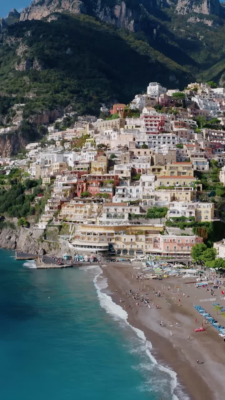 Vista aerea verticale del famoso villaggio di Positano costruito su una terrazza naturale a strapiombo sulla Costiera Amalfitana. Vista aerea di Positano dal Mar Mediterraneo in Italia con una grande nave passeggeri che attracca sulla costa
