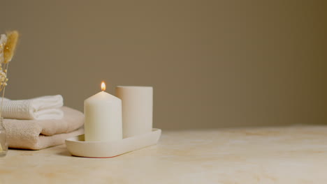 Still-Life-Of-Lit-Candle-With-Dried-Grasses-And-Soft-Towels-As-Part-Of-Relaxing-Spa-Day-Decor-3