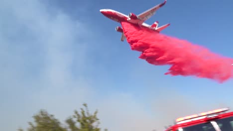 un avión cisterna aéreo hace caer un retardante de fuego phoschek rosa sobre un incendio forestal que arde en las colinas del sur de california 1