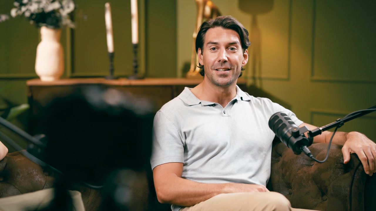 Mand taler under et podcastinterview i et studie