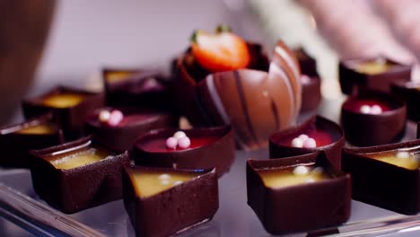 Small-chocolate-cakes-in-candy-bar,-dark-to-bright-light