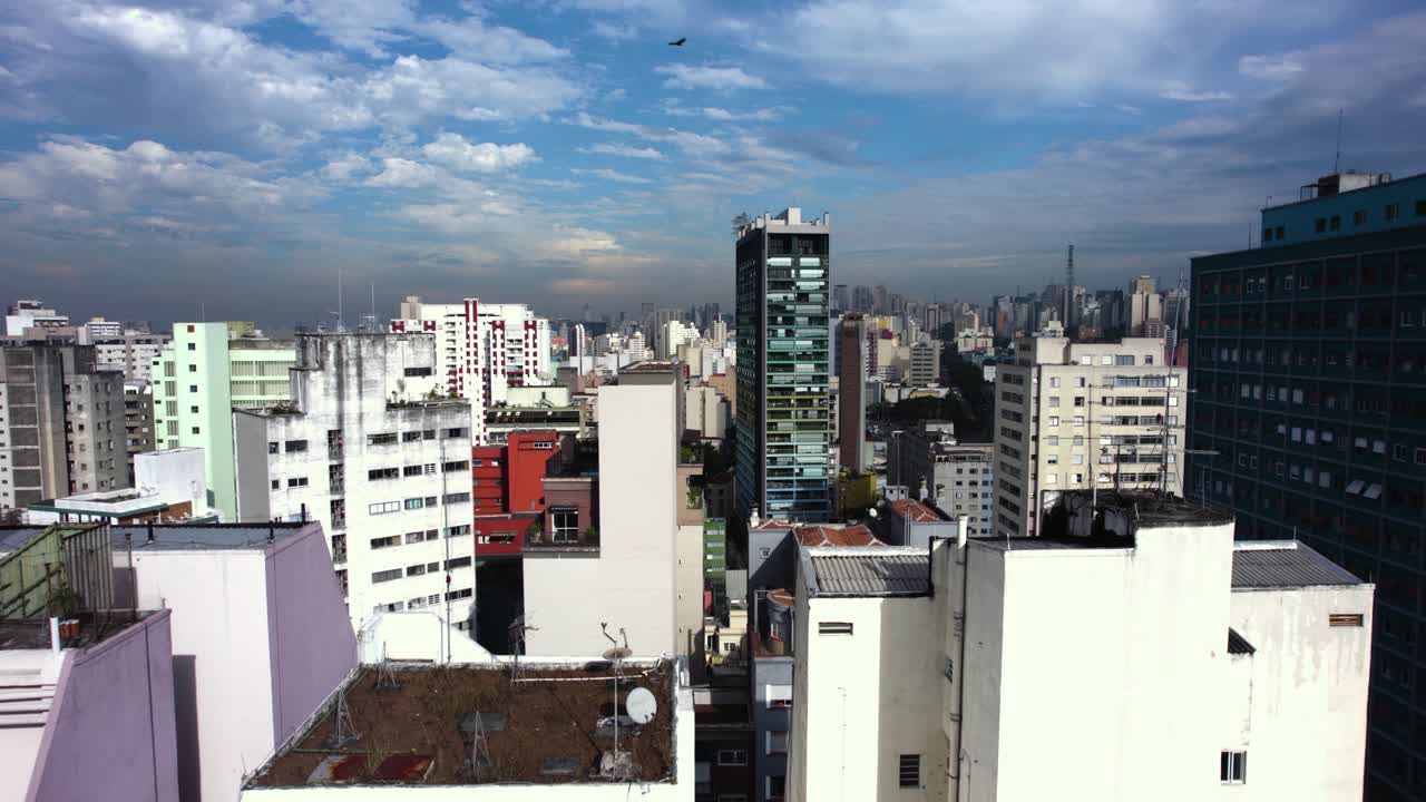 Tomada aérea baixa de condomínios coloridos na Consolação, São Paulo ensolarada, Brasil - rastreamento, movimento de drone