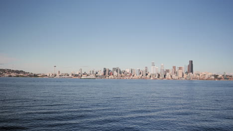 a wide view of the seattle, washington skyline as seen across the elliott bay. a ferry crosses frame