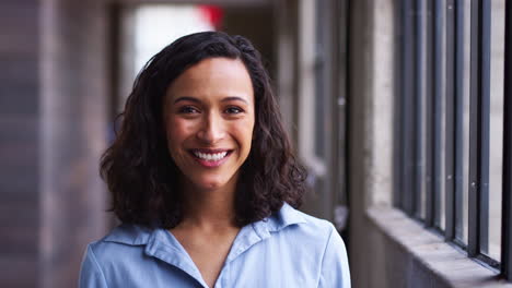 Young-mixed-race-businesswoman-turning-to-camera,-smiling