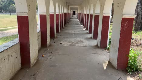 old vacant corridor painted with series of arched openings on both sides in india.