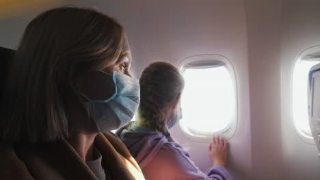 passengers wearing protective masks in the cabin of the aircraft. mother with child on a long flight